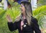 Marina Azevedo waves in front of potted palms on course at Del Mar.