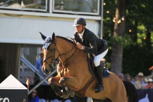 French rider Olivier Guillon pilots his bay horse over a jump.