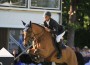 French rider Olivier Guillon pilots his bay horse over a jump.