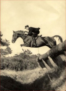 Yves Bienaime on horseback jumping natural obstalces in the field.