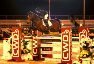 Ashlee Bond and Wistful clear a jump outdoors, under the lights