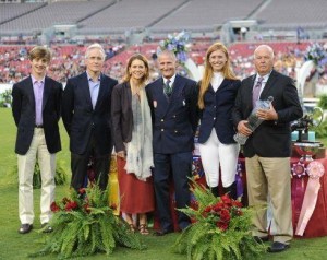 Trophy presentation ceremony on the grass at outdoor stadium.