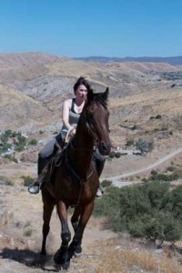 Sara Warner and Tower ride the high country against a bright blue sky.