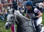 Tiana Coudray smiling aboard her grey horse, Ringwood Magister, as they compete cross country.