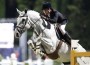 Luciana Diniz rides her grey gelding Winningmood over a large vercital jump.